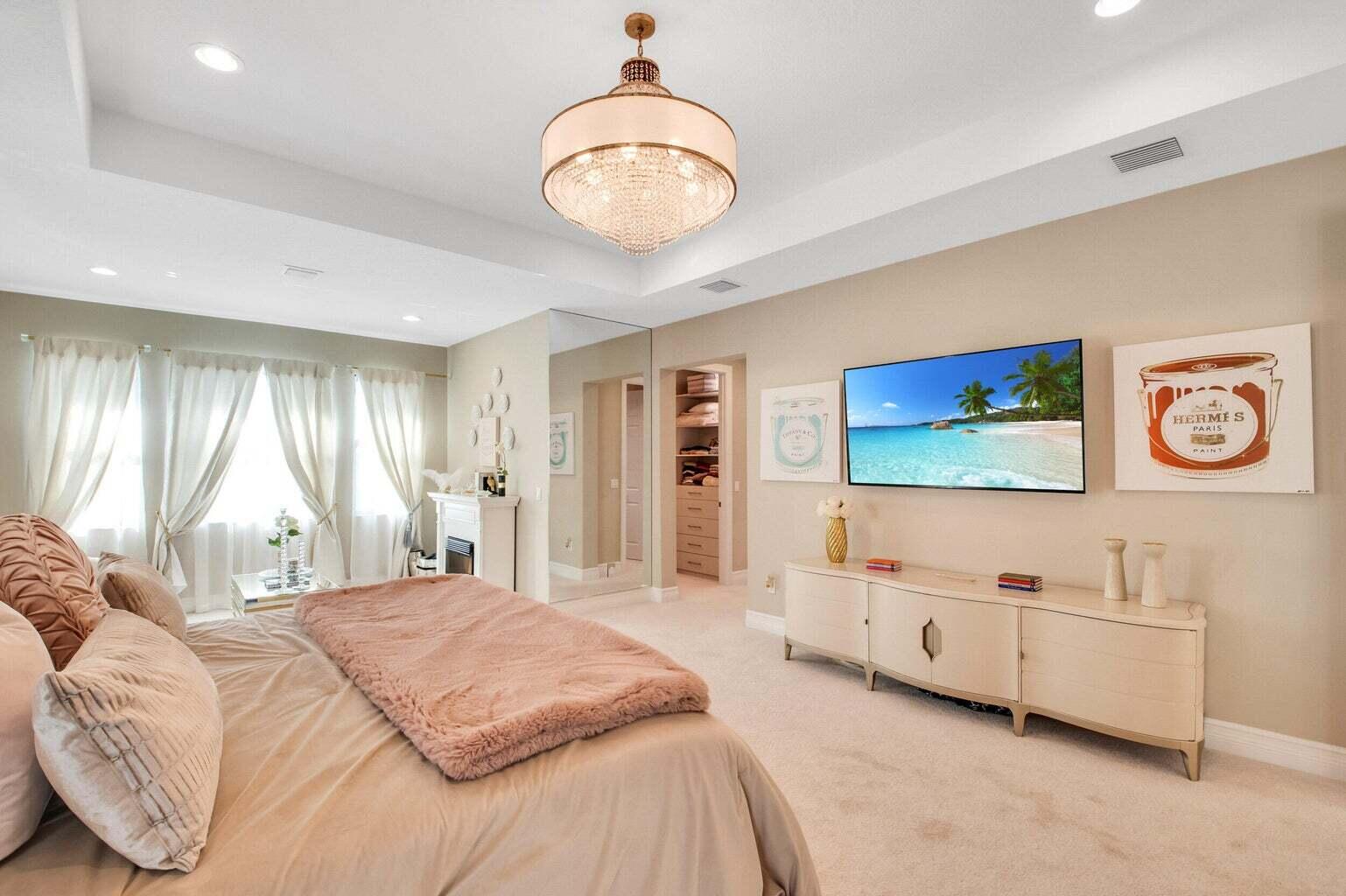9016 Chauvet Way Boca Raton, FL 33496 - Photo 39 of 79 a spacious bedroom with a bed and a chandelier