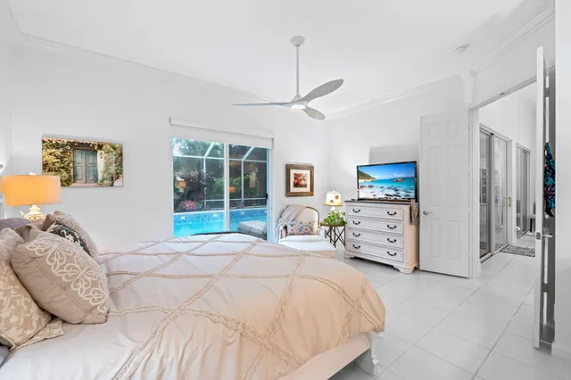a bedroom with a bed a chandelier and dresser