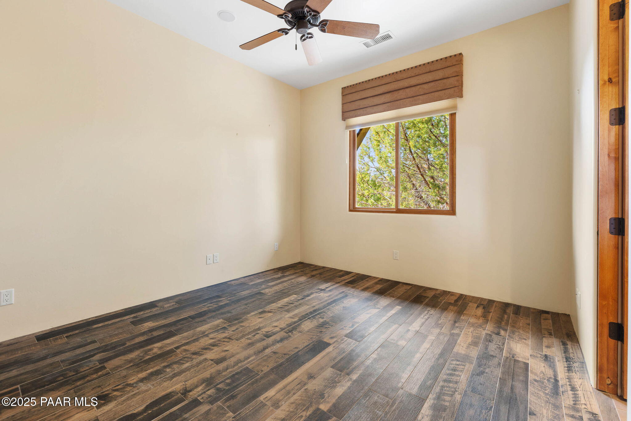 14850 Jay Morrish Drive Prescott, AZ 86305 - Photo 14 of 49 an empty room with wooden floor chandelier fan and windows