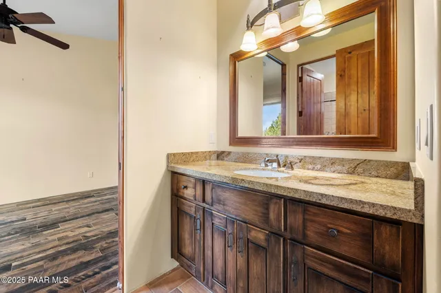 a bathroom with a granite countertop sink and a mirror