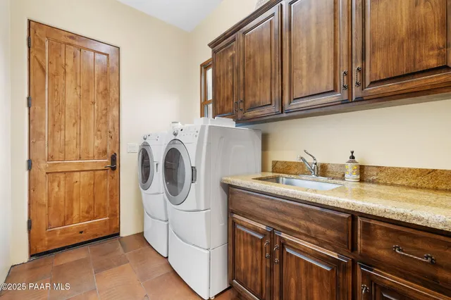 a utility room with sink dryer and washer