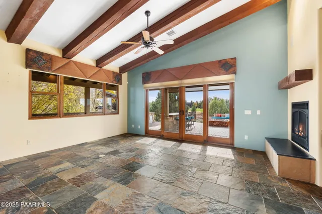 a view of empty room with floor to ceiling window and fireplace