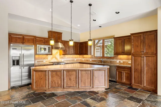 a kitchen with stainless steel appliances granite countertop a stove a refrigerator and a sink