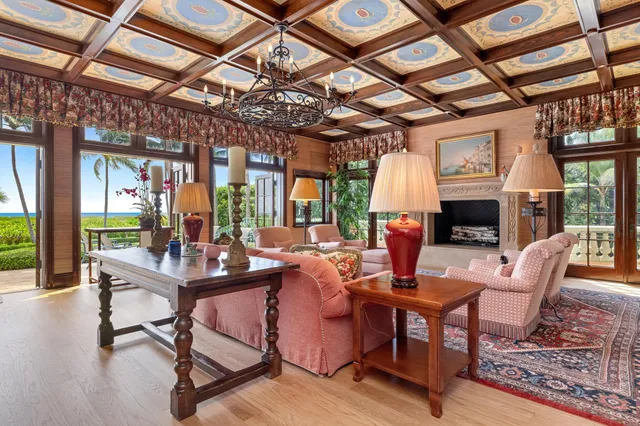 a view of a swimming pool with lawn chairs and palm trees