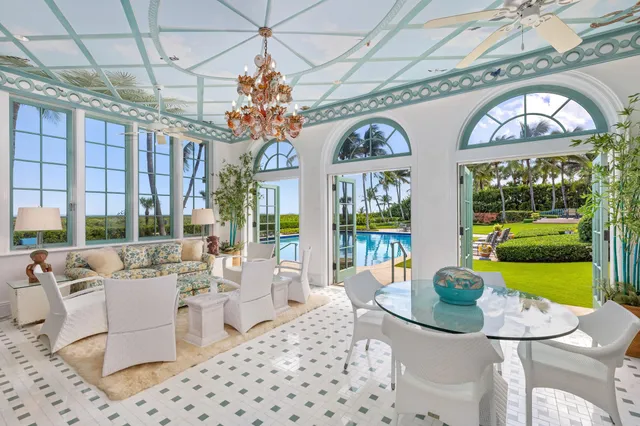 a front view of a building with garden and trees