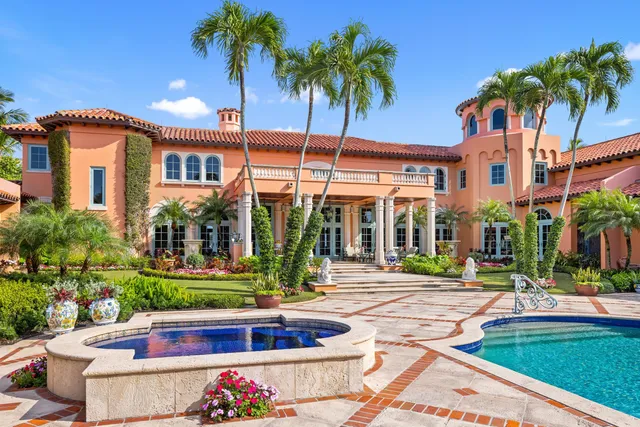 front view of a house with a yard and palm trees