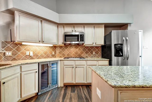 a kitchen with kitchen island granite countertop a stove and a sink