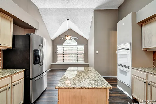 a kitchen with stainless steel appliances granite countertop a refrigerator and a sink