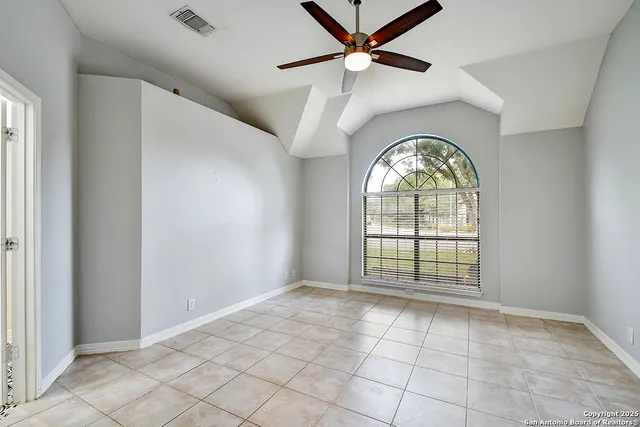 an empty room with windows and fan