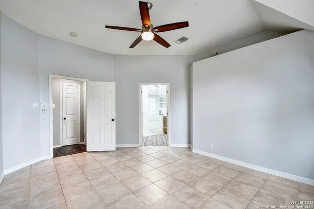 a view of an empty room and a ceiling fan