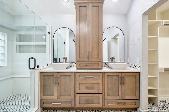 a bathroom with double vanity sinks and a mirror