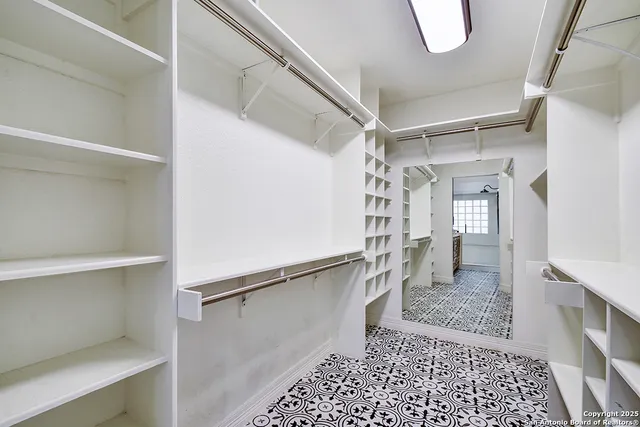 a view of walk in closet with empty racks