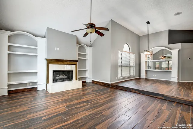 a view of a livingroom with wooden floor a fireplace and window
