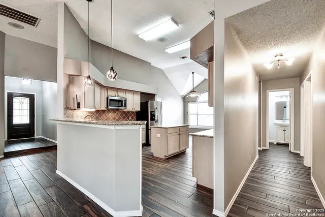 a kitchen with a refrigerator and wooden floor