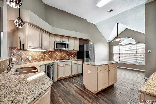 a kitchen with stainless steel appliances granite countertop a sink stove and refrigerator