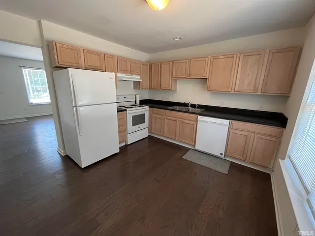 a kitchen with a sink a refrigerator a microwave and cabinets