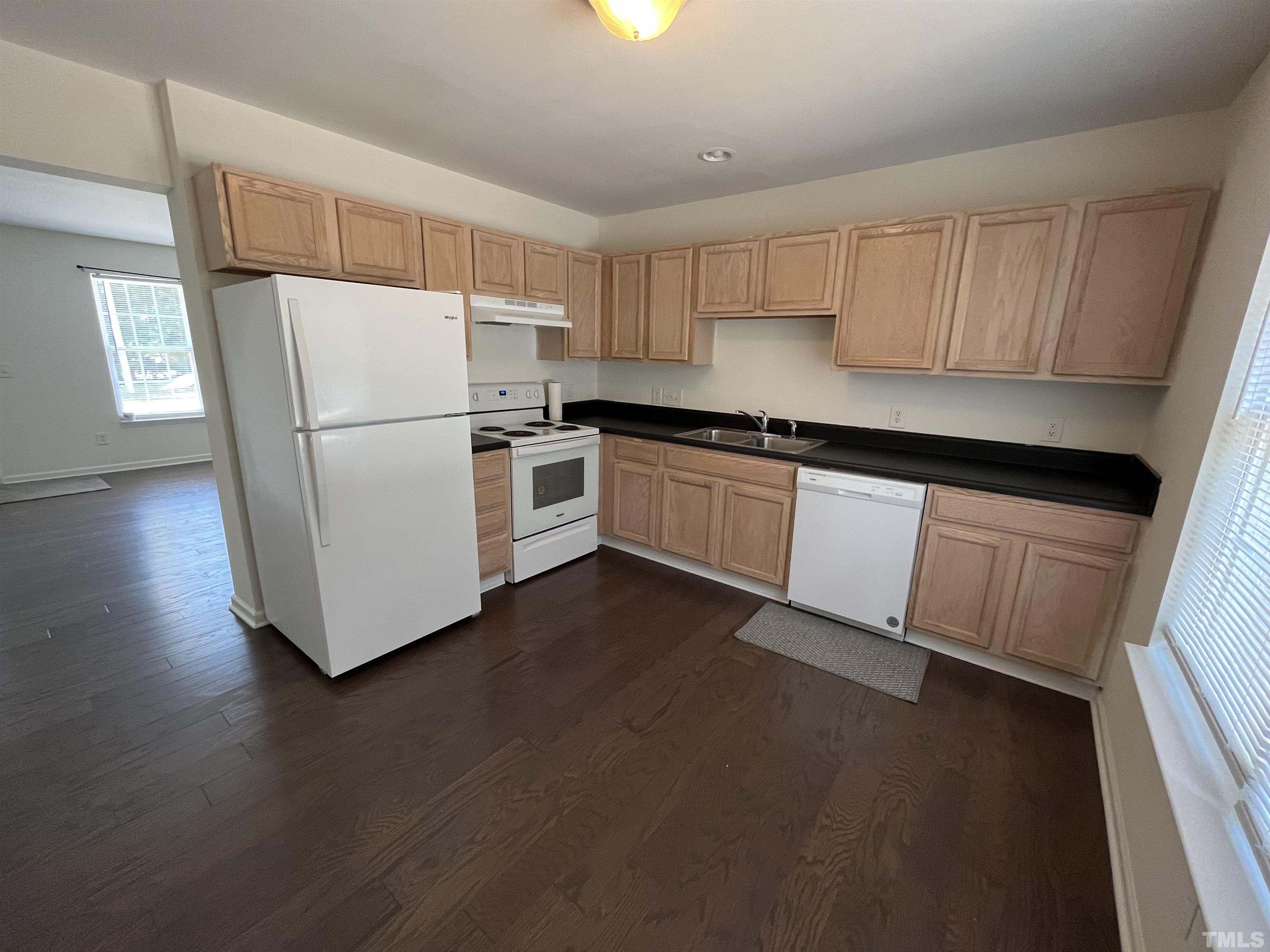 23 Red Lane Raleigh, NC 27606 - Photo 2 of 13 a kitchen with a sink a refrigerator a microwave and cabinets