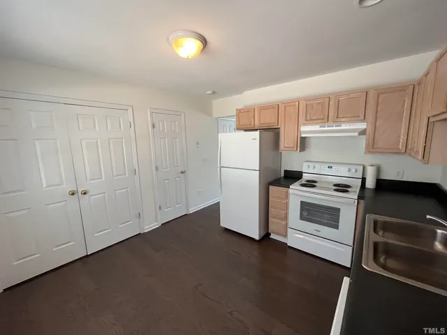 a kitchen with a refrigerator stove and white cabinets