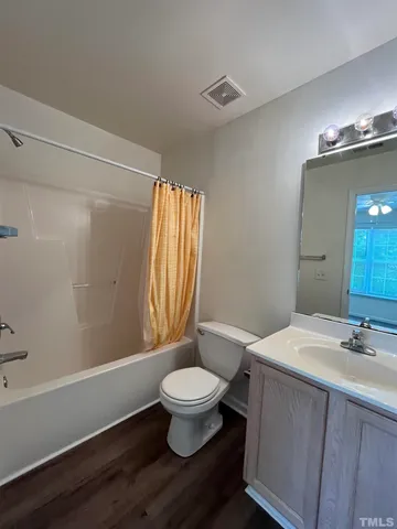 a bathroom with a sink a toilet a mirror and shower