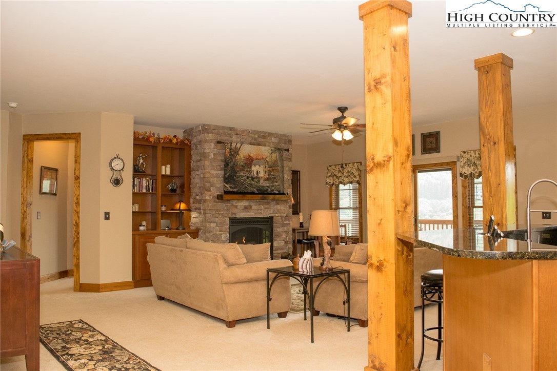114 Red Deer Road, Unit D Banner Elk, NC 28604 - Photo 18 of 40 a living room with furniture a fireplace and a chandelier