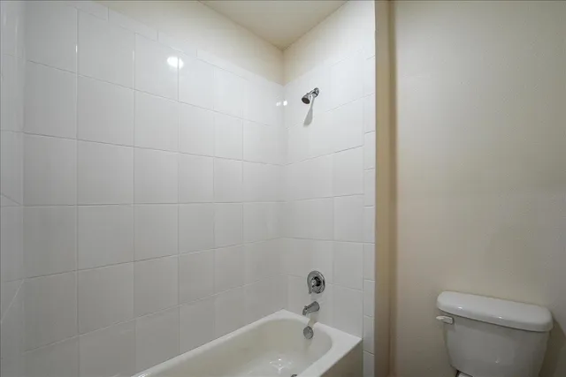 a bath room with a toilet and a bath tub