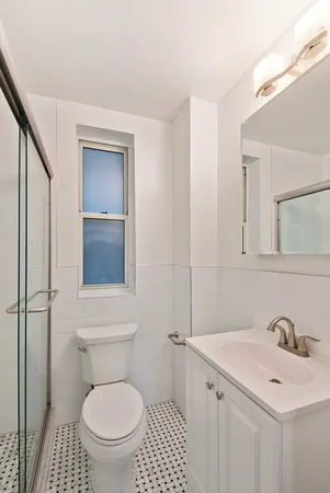 a bathroom with a toilet a sink and mirror