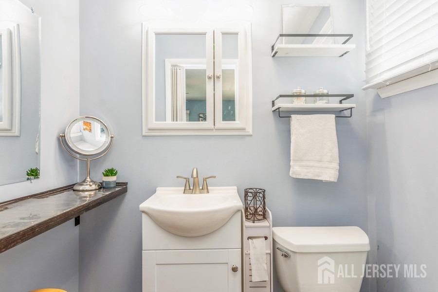 27 Brookside Road Edison, NJ 08817 - Photo 12 of 30 a bathroom with a toilet a sink and mirror