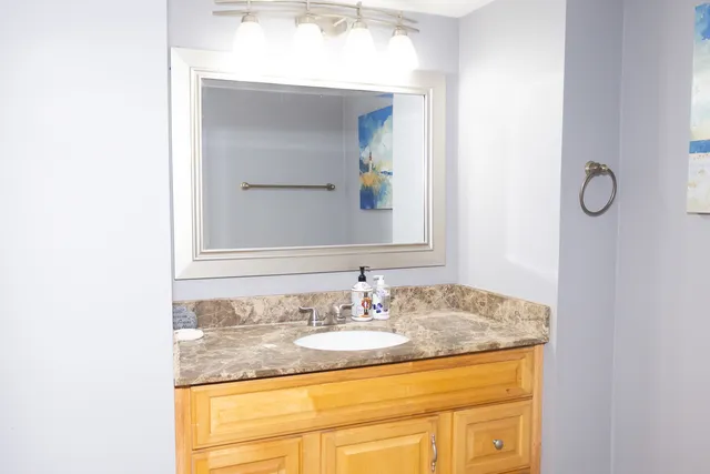 a bathroom with a granite countertop sink and a mirror