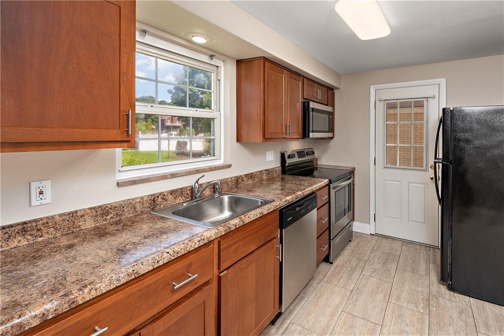 908 Greenhill Road Pittsburgh, PA 15209 - Photo 11 of 23 a kitchen with granite countertop a sink stove and refrigerator
