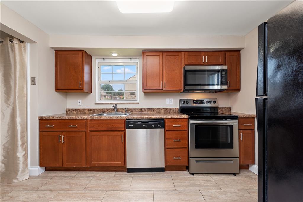 908 Greenhill Road Pittsburgh, PA 15209 - Photo 12 of 23 a kitchen with stainless steel appliances granite countertop a stove a sink and a microwave