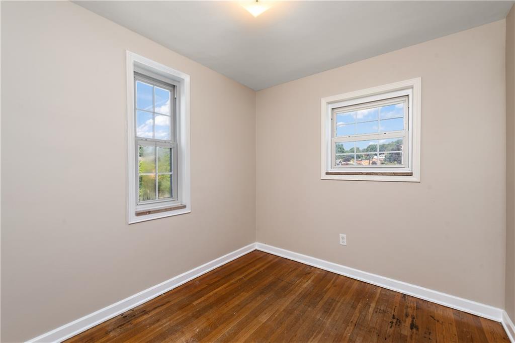 908 Greenhill Road Pittsburgh, PA 15209 - Photo 15 of 23 a view of an empty room with wooden floor and a window