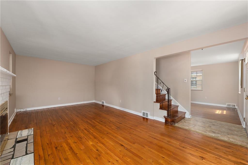 908 Greenhill Road Pittsburgh, PA 15209 - Photo 18 of 23 an empty room with wooden floor and staircase