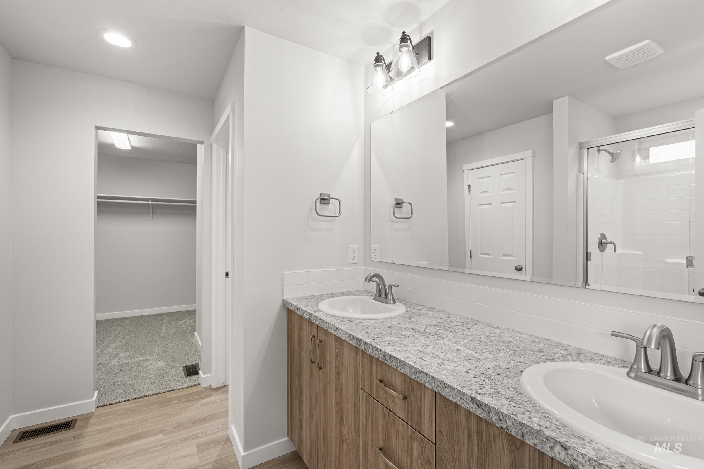 13693 Redway Court Caldwell, ID 83607 - Photo 22 of 25 Full bathroom with double vanity, light wood finished floors, a stall shower, a spacious closet, and recessed lighting