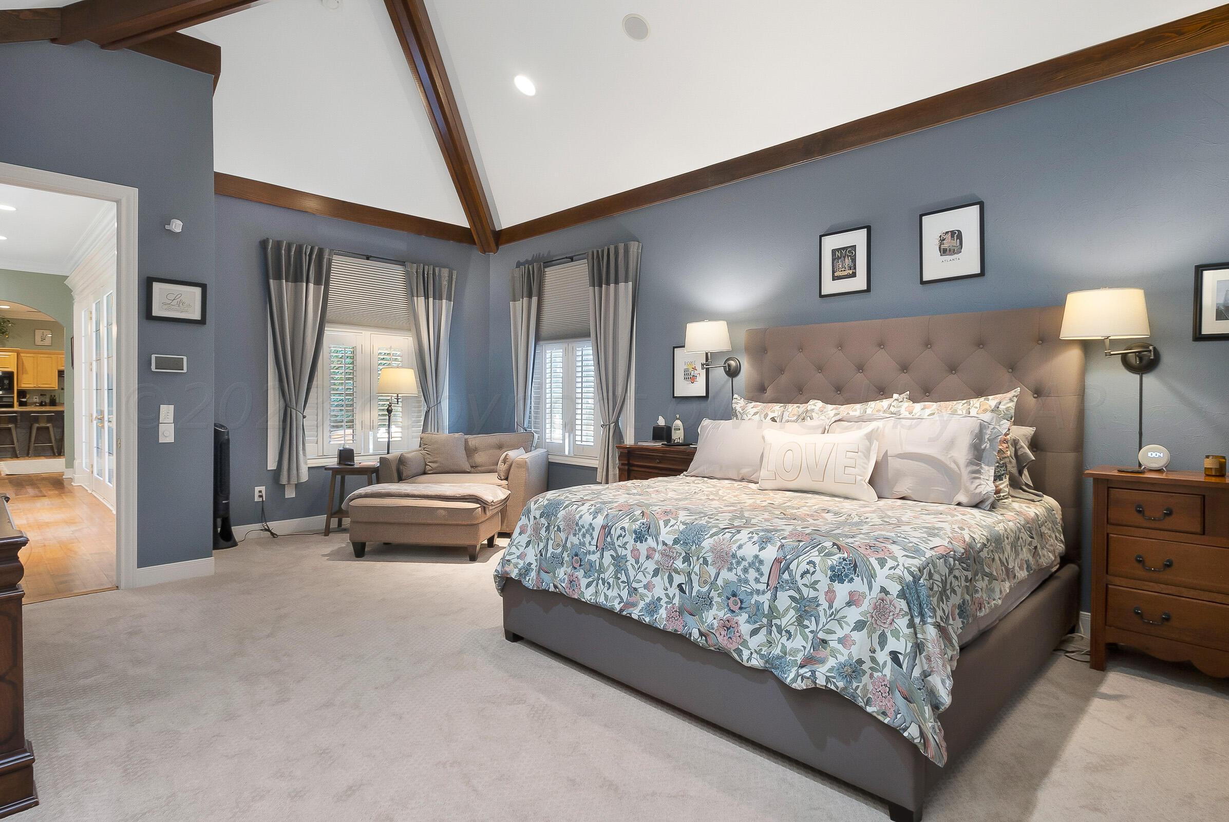 6202 Raintree Court Amarillo, TX 79119 - Photo 17 of 36 a bedroom with a large bed and a chandelier