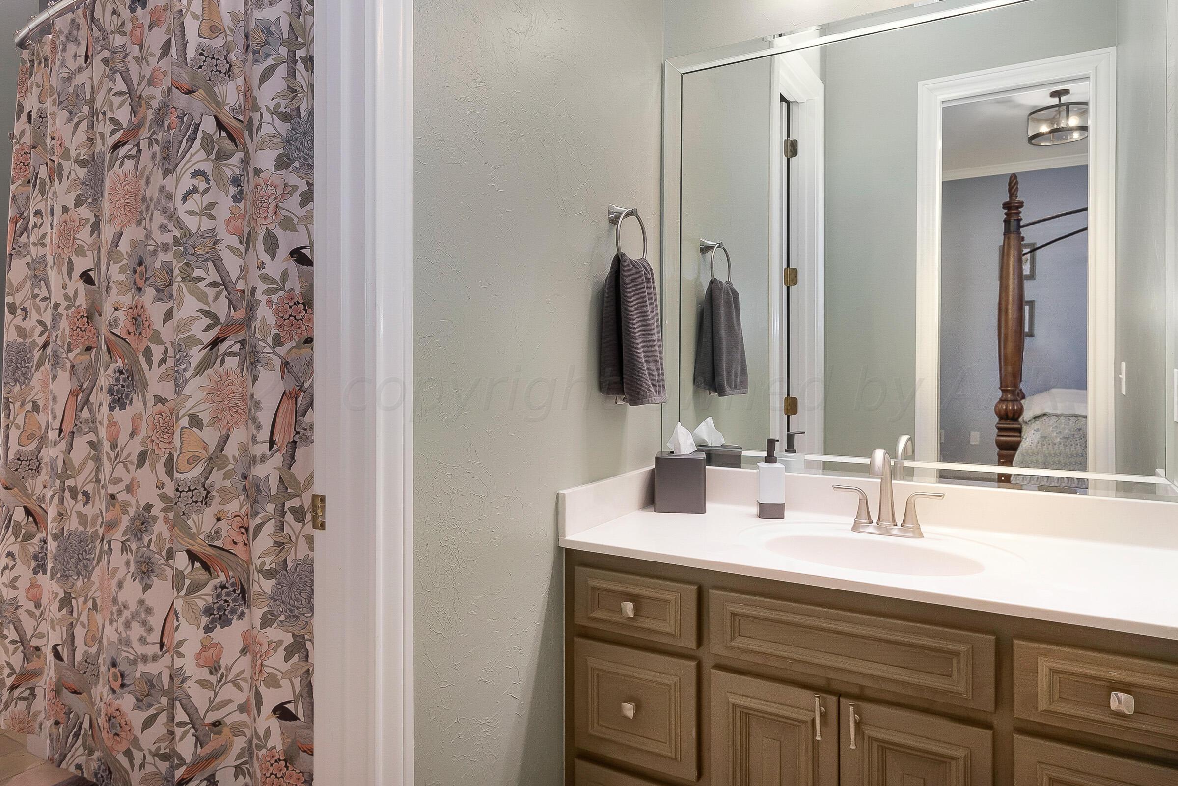6202 Raintree Court Amarillo, TX 79119 - Photo 23 of 36 a bathroom with a double vanity sink and a mirror