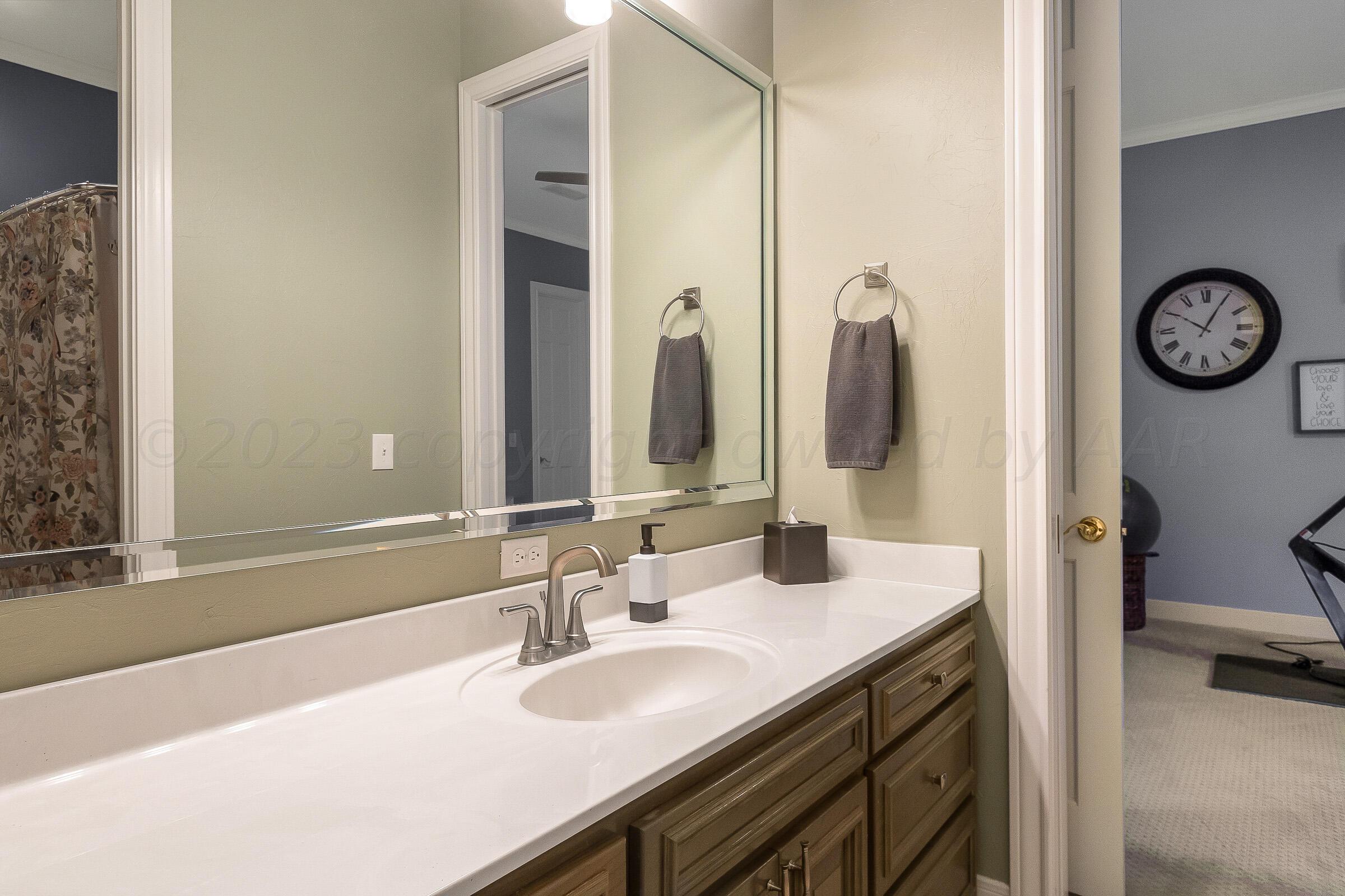 6202 Raintree Court Amarillo, TX 79119 - Photo 25 of 36 a bathroom with a double vanity sink and a mirror