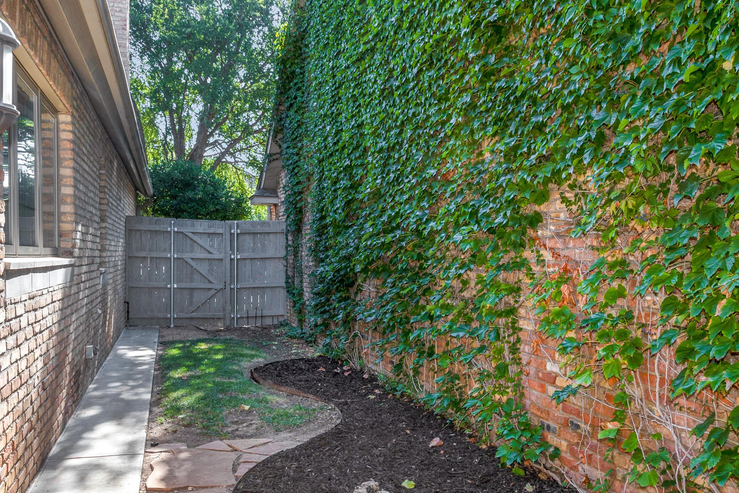 6202 Raintree Court Amarillo, TX 79119 - Photo 32 of 36 a view of a backyard with plants and wooden fence