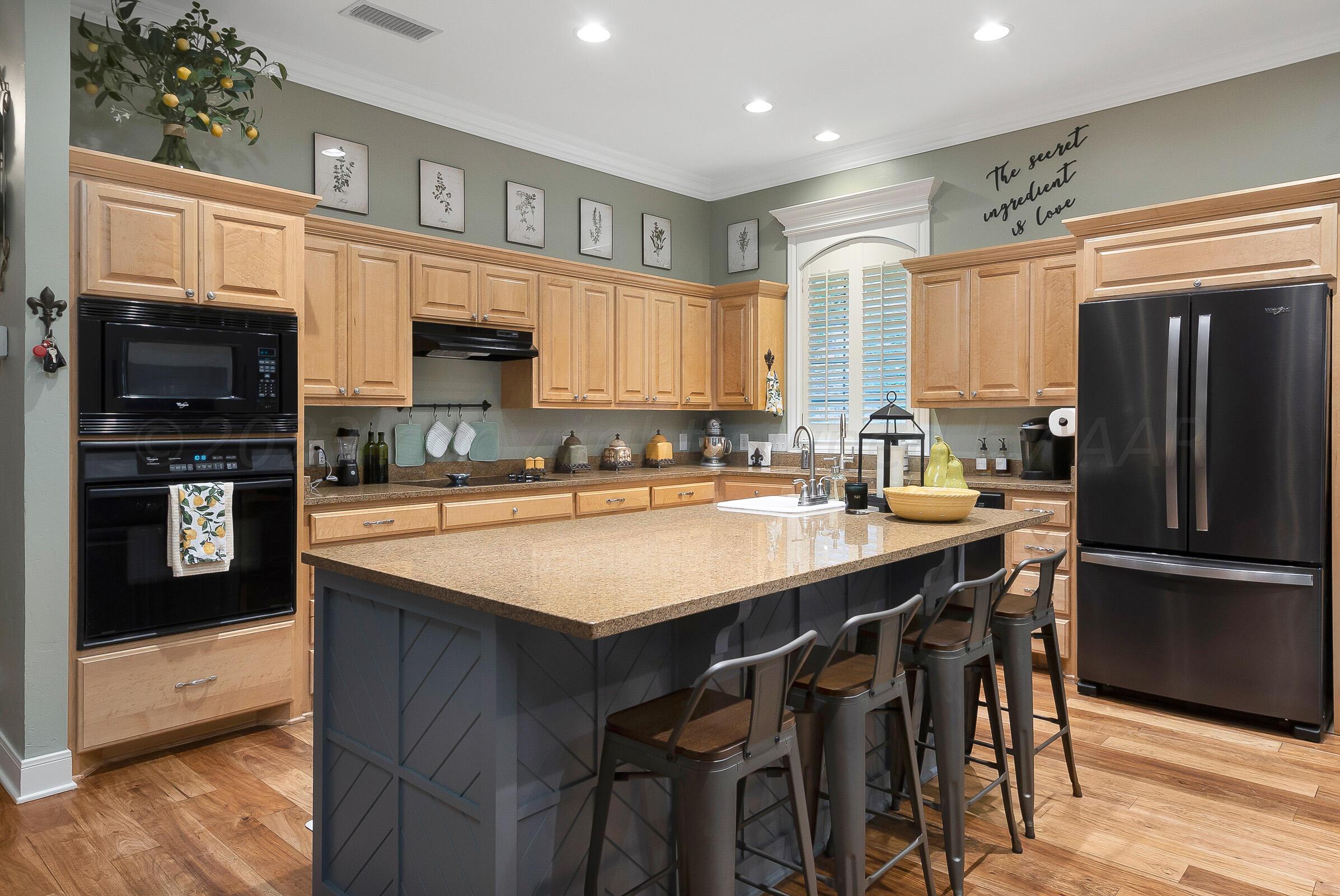 6202 Raintree Court Amarillo, TX 79119 - Photo 9 of 36 a kitchen with stainless steel appliances granite countertop a table chairs sink refrigerator and cabinets
