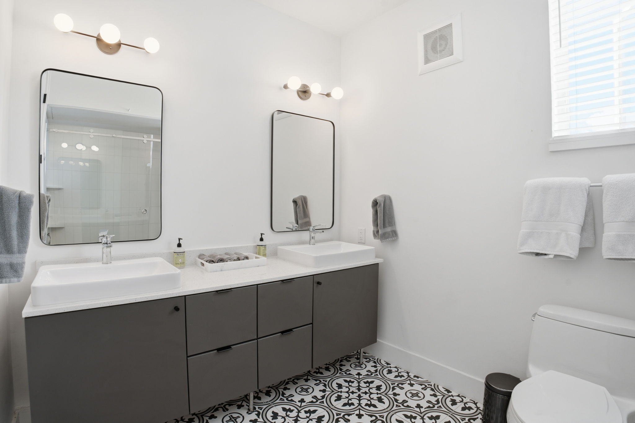 2709 East 5th Street, Unit 1306 Austin, TX 78702 - Photo 15 of 28 A well-appointed bathroom boasts a double vanity, patterned tile flooring, and ample illumination.