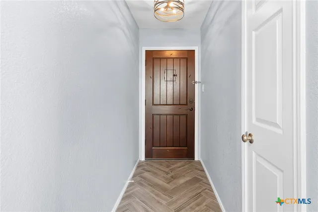 a view of a hallway with wooden floor and closet