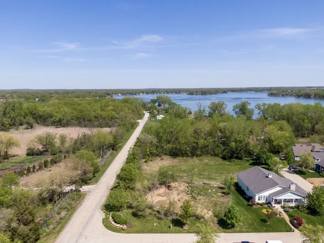 an aerial view of lake and residential houses with outdoor space