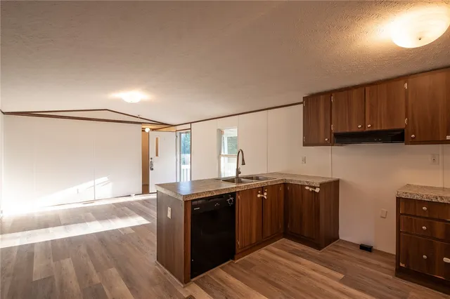 a kitchen with stainless steel appliances granite countertop a sink stove and cabinets