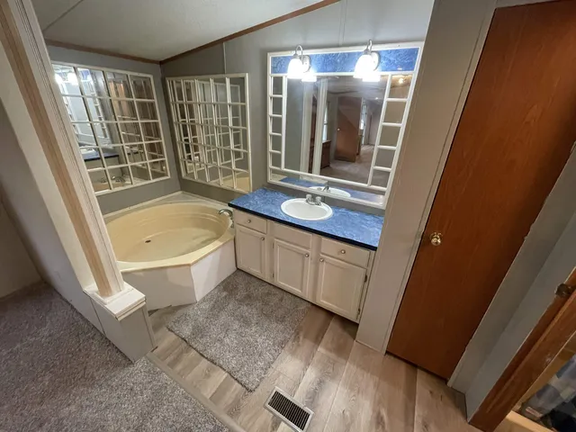 a bathroom with a granite countertop sink and a bathtub