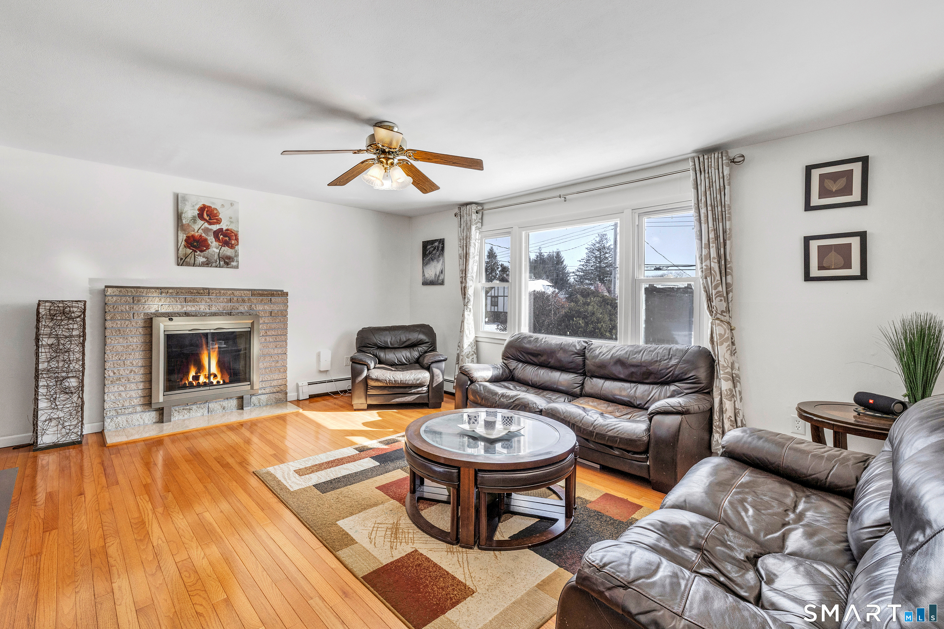 39 Zephyr Road Trumbull, CT 06611 - Photo 13 of 36 a living room with furniture a fireplace and a flat screen tv
