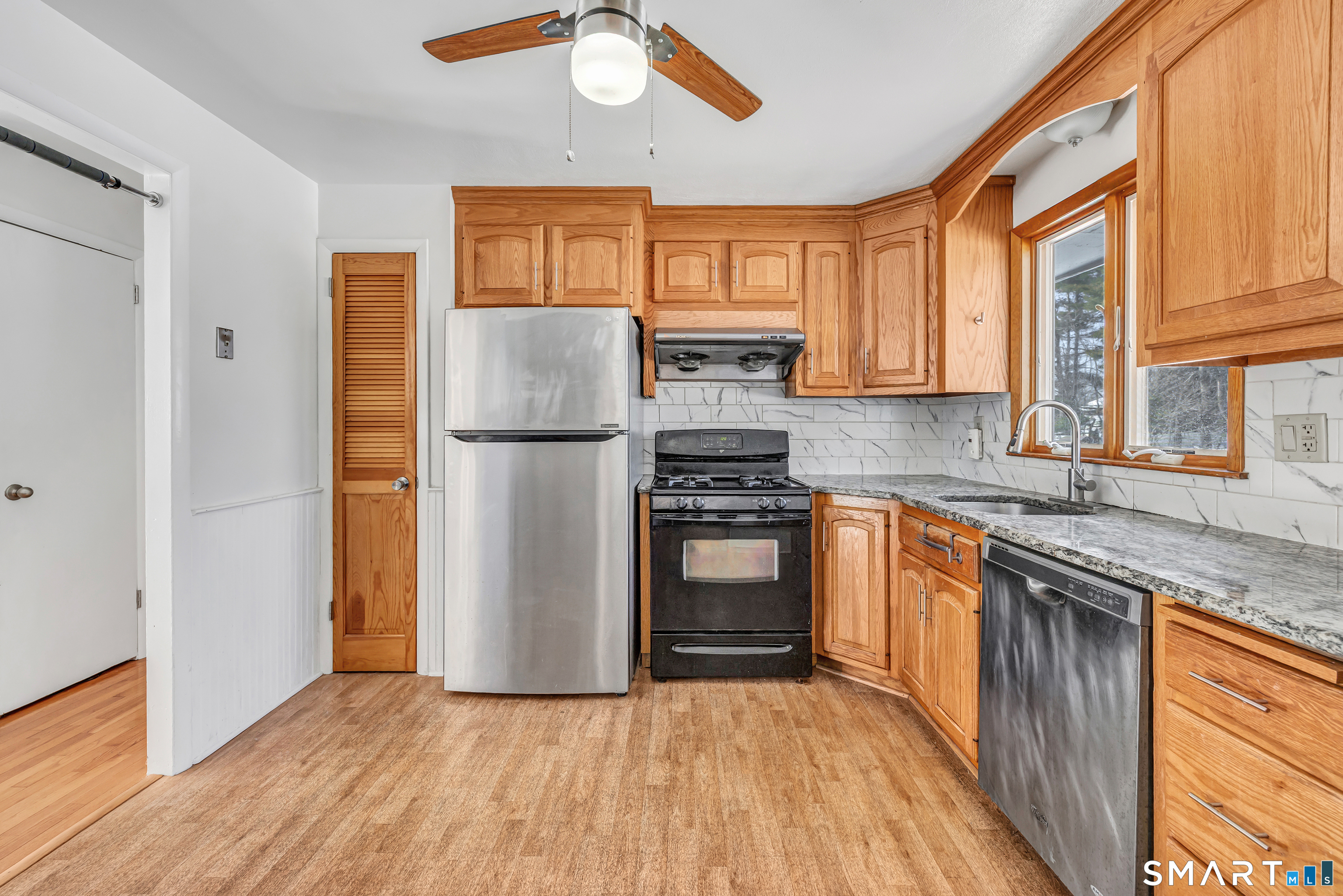 39 Zephyr Road Trumbull, CT 06611 - Photo 22 of 36 a kitchen with granite countertop stainless steel appliances a refrigerator cabinets and wooden floor