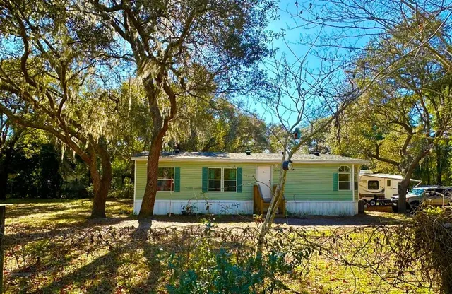a front view of a house with a tree