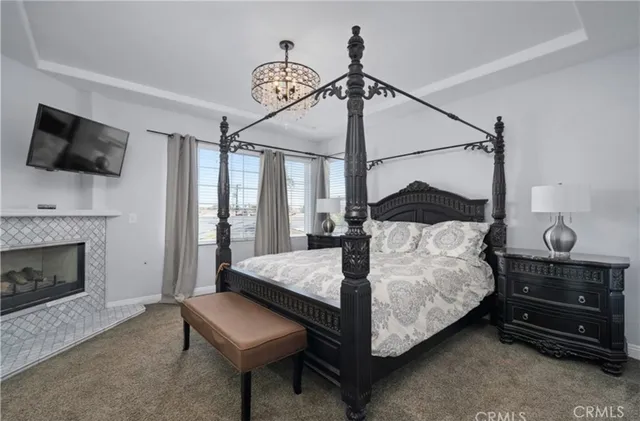 a bedroom with a bed a fireplace and a television