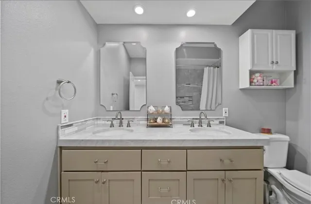 a bathroom with double vanity and a mirror