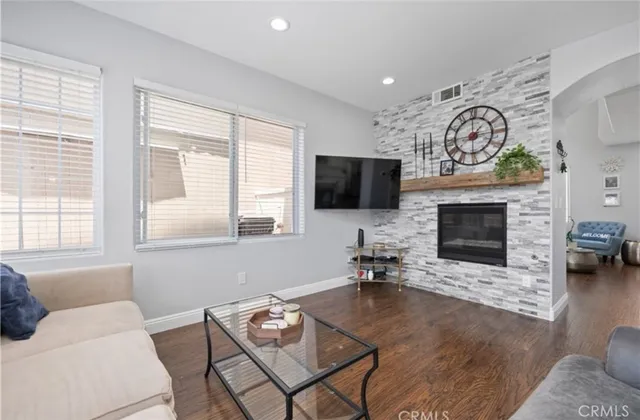 a living room with furniture a fireplace and a flat screen tv