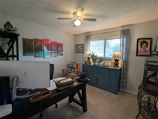 a room with furniture a ceiling fan and a window